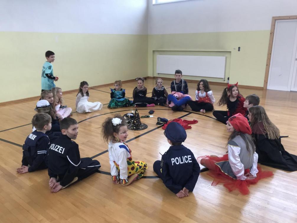 Bild zeigt verkleidete Kinder, die ein Kreisspiel spielen