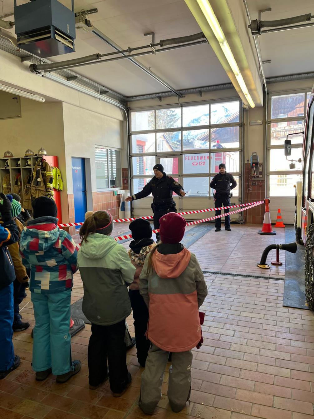 Kinder mit Polizisten bei der Veranschaulichung eines toten Winkels