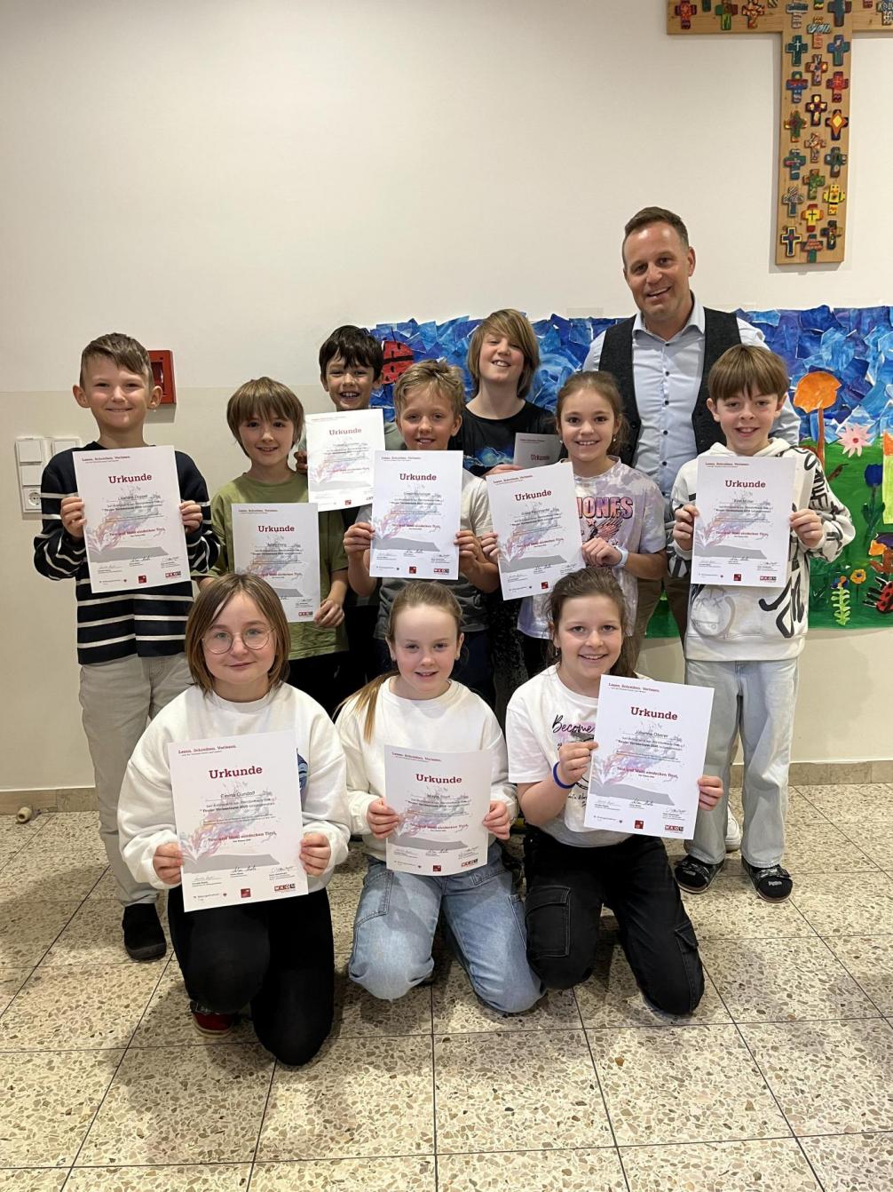 Kinder mit ihren Urkunden und Schulqualitätsmanager Simon 