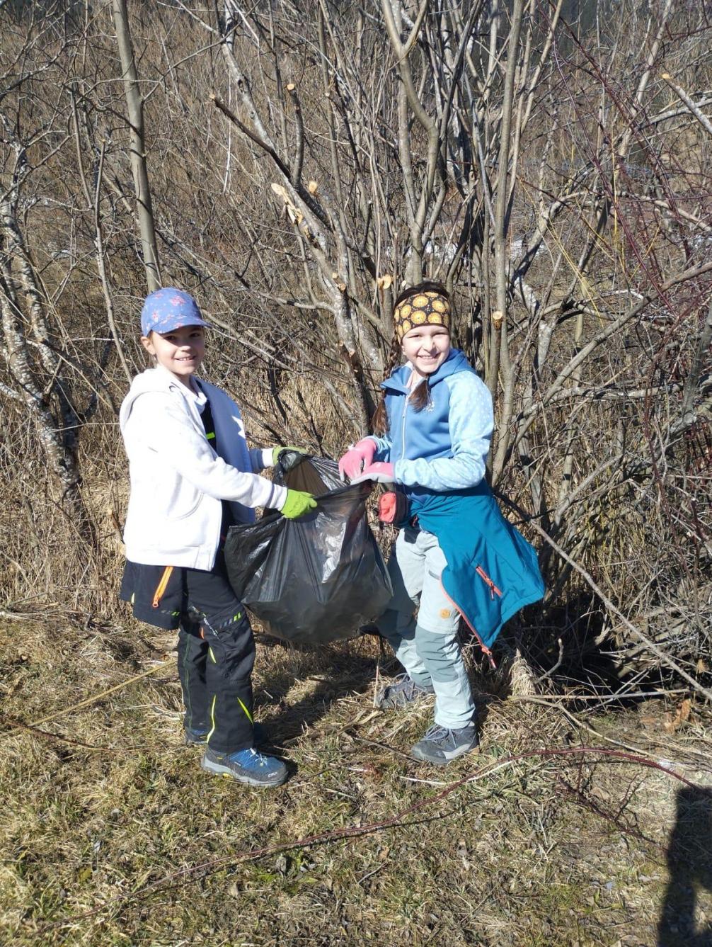 Zwei Kinder mit einem vollen Müllsack