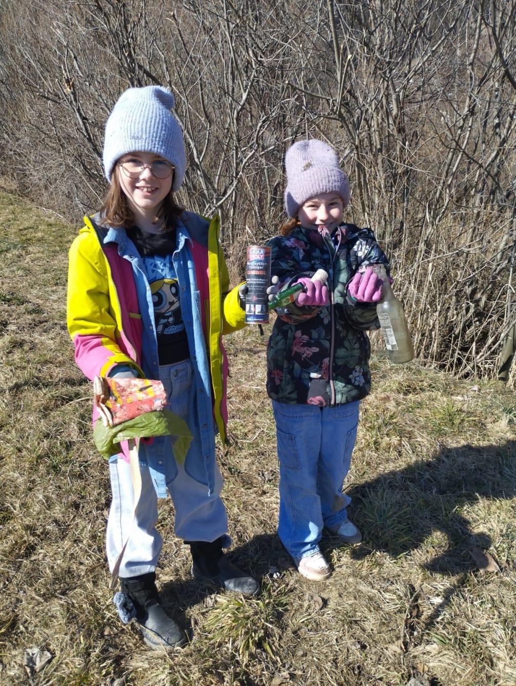 Zwei Kinder mit Müll in den Händen