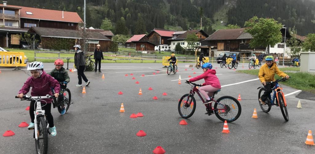 Kinder mit Fahrrädern auf dem Parkplatz im Parkour