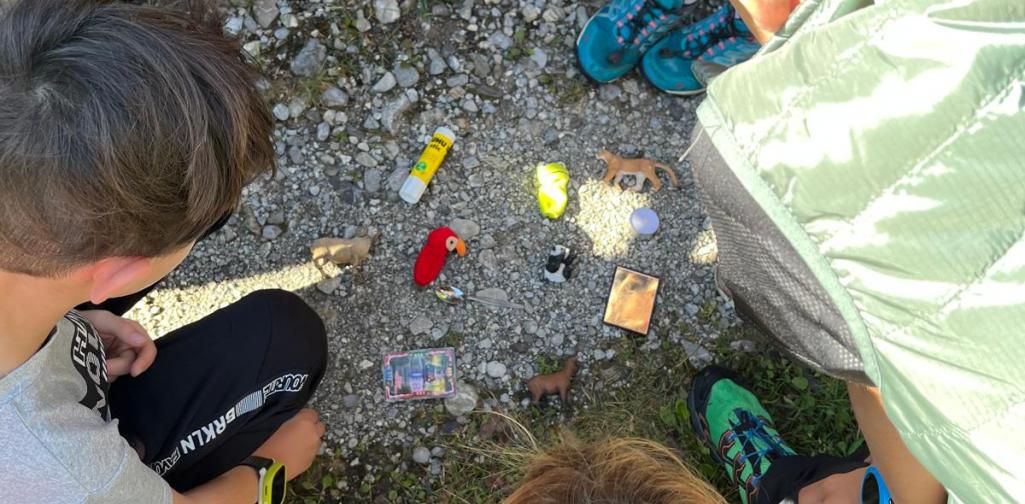 Waldschule 4 Kinder im Kreis mit ihren gefundenen Dingen